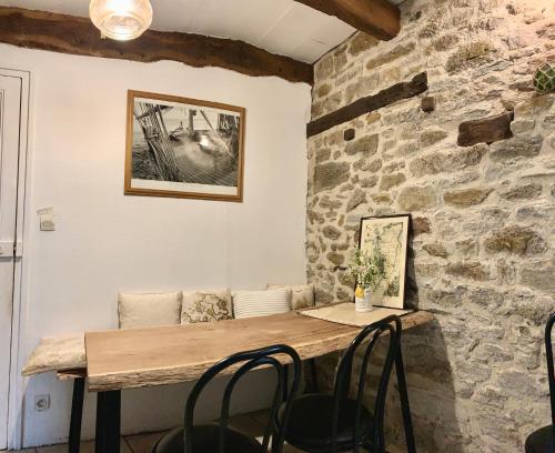 une table dans une pièce avec un mur en pierre dans l'établissement Chambres d'Hôtes du Manoir du Haut Salmon, à Saint-Malo