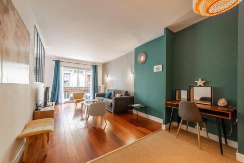 Elle comprend un salon avec des murs verts, un bureau et des chaises. dans l'établissement L'étoile annécienne - 3 rooms 80 square meter - Terrace, à Annecy