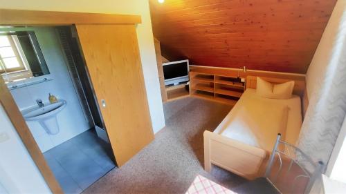 a small bathroom with a bed and a television at Gasthof Lamprecht in Peiting
