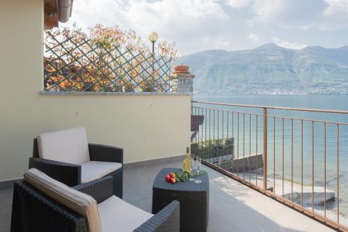 a balcony with chairs and a view of the water at Dream Lake Apartments Lake View - private beach by Rent All Como in Lezzeno