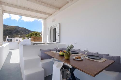 a dining room with a wooden table and chairs at Blue Soul Luxury Villa in Éxo Goniá
