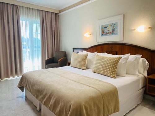 um quarto de hotel com uma cama grande e uma janela em Nuevo Astur Spa em Sanxenxo