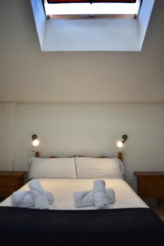 a bedroom with a bed with white towels on it at Hotel El Ancla in Villanueva de la Cañada
