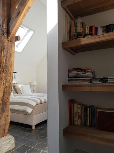 a bedroom with a bed and a book shelf with books at bij Saar in Zwinderen