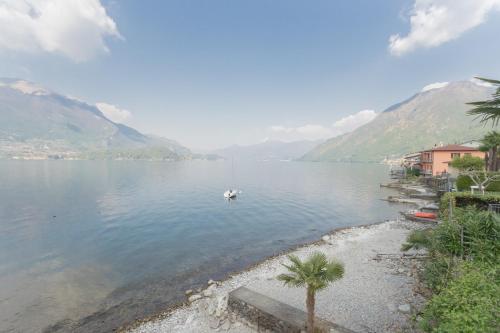 a view of a lake with a boat in the water at Dream Lake Apartments Lake View - private beach by Rent All Como in Lezzeno
