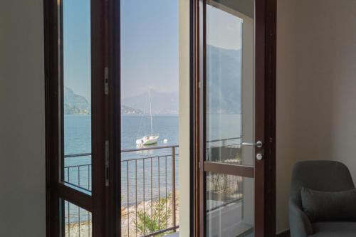 a room with a balcony with a view of the ocean at Dream Lake Apartments Lake View - private beach by Rent All Como in Lezzeno