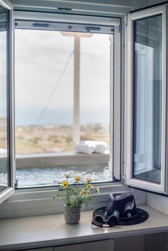 a window with a hat and a flower on a window sill at Blue Soul Luxury Villa in Éxo Goniá