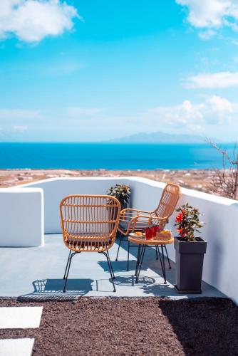 two chairs and a table on a patio overlooking the ocean at Blue Soul Luxury Villa in Éxo Goniá