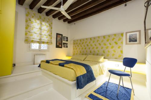 ヴェネツィアにあるBlueYellow home in Cannaregio Air conditioning WiFiのベッドルーム(黄色のベッド1台、青い椅子付)