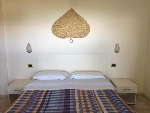 a bedroom with a bed with two tables and a chandelier at Elena Club Resort in Silvi Marina