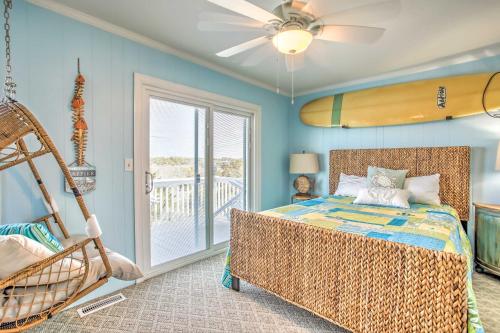 a bedroom with a bed and a surfboard on the wall at Coastal Oasis with Decks Walk to Holden Beach! in Holden Beach