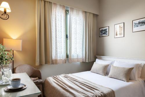 a bedroom with a bed and a table and a window at Tourist Boutique Hotel in Argostoli