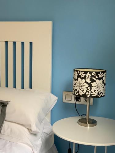 a lamp on a table next to a bed at Apartaments El Cine in Roses