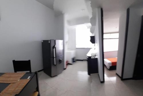 a room with a hallway with a refrigerator in it at Apartamentos y Piscina a 3 min del Parque Cafe in Montenegro