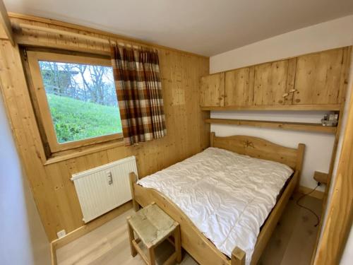 ein kleines Schlafzimmer mit einem Bett und einem Fenster in der Unterkunft Le Courtis au Bourjaillet in Notre-Dame-de-Bellecombe