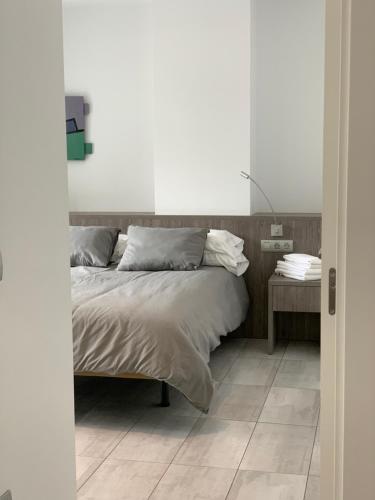 a bedroom with a bed and a tiled floor at Apartaments El Cine in Roses