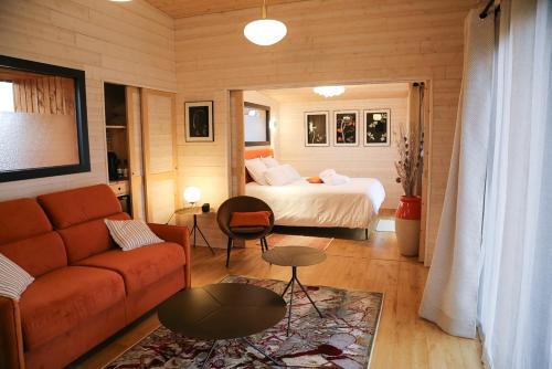 sala de estar con cama y sofá en Les Lodges du golf de la Marterie en Saint-Félix-de-Reillac-et-Mortemart