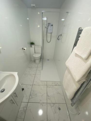 a white bathroom with a shower and a sink at Barriemore Oban in Oban
