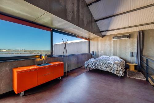 a bedroom with a bed and a large window at The Loft - a birdwatchers paradise in Fuzeta