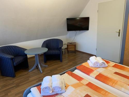 a room with two beds and a table and a tv at Ferienhaus Schonerweg 9 in Norddeich in Norddeich