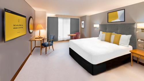 a hotel room with a bed and a desk at voco Reading in Reading