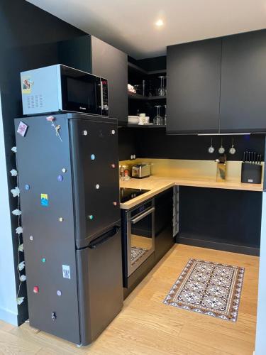 une cuisine avec un réfrigérateur et un micro-ondes dans l'établissement Le Vieljeux, Vieux port La Rochelle, à La Rochelle