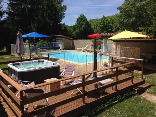 une terrasse avec un bain à remous à côté d'une piscine dans l'établissement Les Reves, à Arques