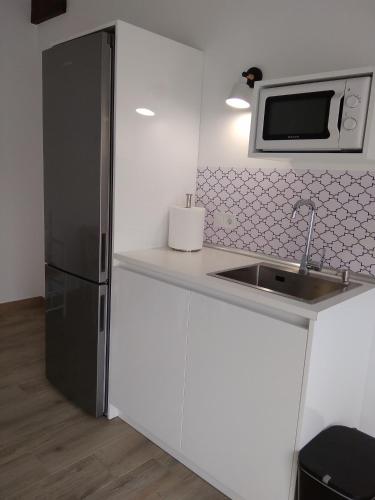 a kitchen with a black refrigerator and a microwave at Posada Tresvalle in Ubiarco