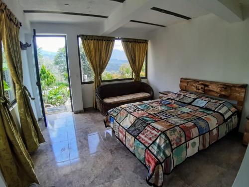 een slaapkamer met een bed, een stoel en een raam bij Hospedaje Rural El Rancho de Amelia y Juancho in Silvania