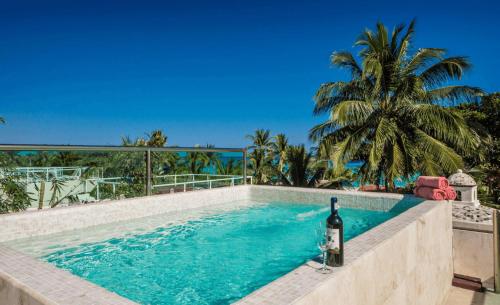 una piscina con una botella de vino junto a ella en Luxury Villa steps to the beach, en Playa del Carmen