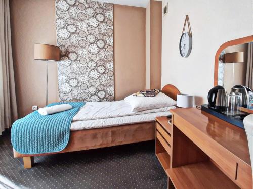 een hotelkamer met een bed en een bureau met een spiegel bij RB Rooms&Apartments in Bydgoszcz