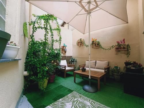 ニースにあるNice appartement cosy + patio privéの植物とテーブルと傘が備わる部屋
