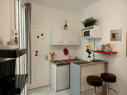 ニースにあるNice appartement cosy + patio privéの小さなキッチン(白いキャビネット、電子レンジ付)