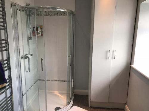 a shower with a glass door in a bathroom at West Strand View in Portrush