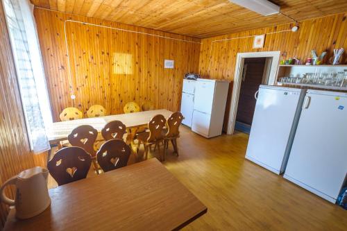 a kitchen with a table and chairs and a refrigerator at Nostalgija Pervalkoje in Neringa