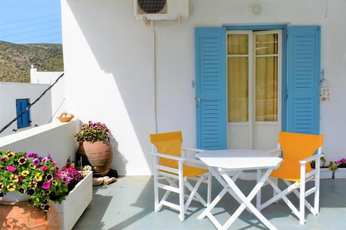 a table and chairs on the porch of a house at Angeliki Pension in Katapola