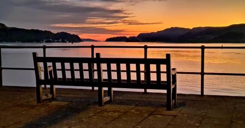 a bench sitting in front of a body of water at Barriemore Oban in Oban