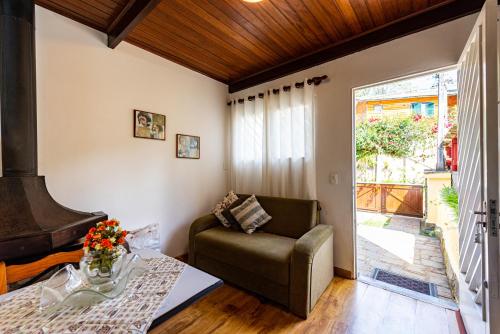 a living room with a couch and a table at Ap Casal Localização e Segurança in Campos do Jordão