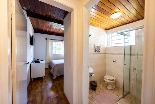 een badkamer met douche en toilet in een kamer bij Ap Casal Localização e Segurança in Campos do Jordão