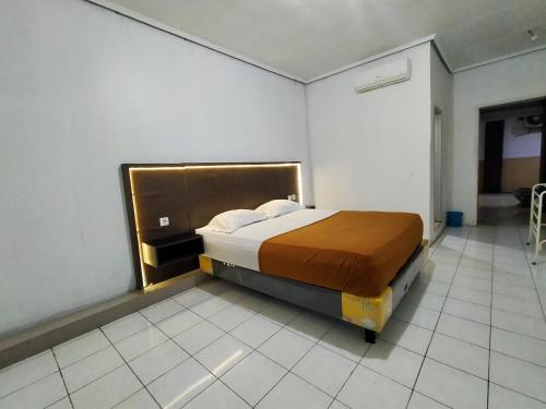 ein Schlafzimmer mit einem großen Bett in einem Zimmer in der Unterkunft Hotel Nirwana Ternate RedPartner in Ternate