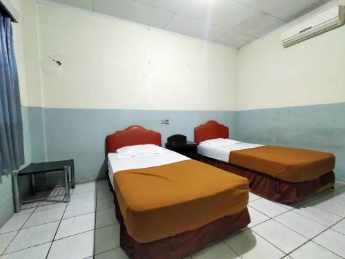 a room with two beds in a room at Hotel Nirwana Ternate RedPartner in Ternate