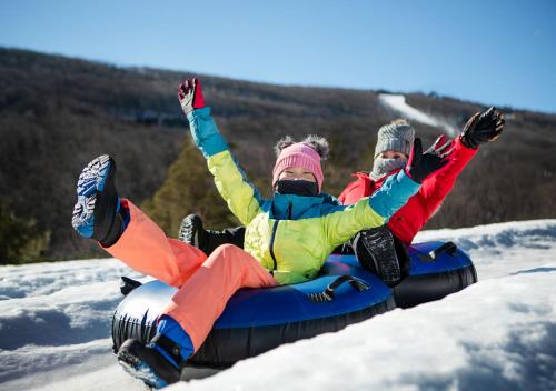 two people are riding on a snowboard in the snow at Camelback Resort in Tannersville