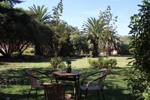 una mesa y sillas en un patio con árboles en El Arbol Eco Lodge en La Serena