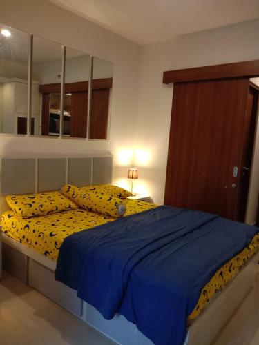 a bedroom with a bed with yellow sheets and pillows at Bintang Room in Cikunir Satu