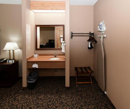 y baño con lavabo y espejo. en Cobblestone Inn & Suites - Denison | Majestic Hills, en Denison