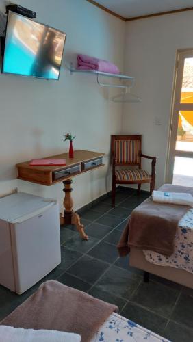 a room with a desk and a chair and a table at Pousada Casa Doce Vida in Águas de Lindóia