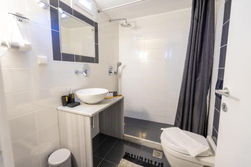 a bathroom with a sink and a toilet at Family Villages Santorini in Vlychada Beach