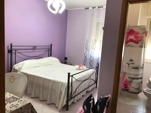 a purple bedroom with a bed and a mirror at Hotel Degli Amici in Sant'Egidio del Monte Albino