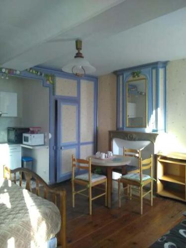 a room with a table and chairs and a bedroom at Chambres d'hôtes les Clématites en Cotentin in Saint-Floxel