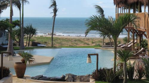 a swimming pool with the beach in the background at Hurricane Jeri in Jericoacoara